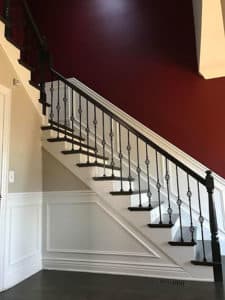 Black railing and step staircase with a red wall