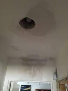 White ceiling with a lightbulb in a hole