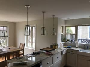 A kitchen with three hanging ceiling lights