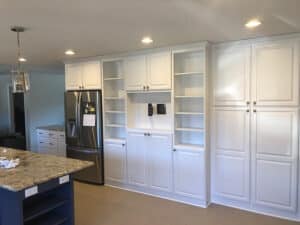 White kitchen cabinets next to refrigerator