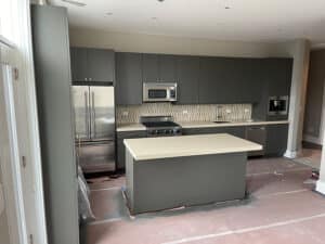 Angled shot of kitchen with island and grey cabinets