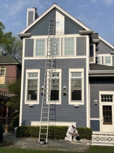 Man next to ladder on side of house