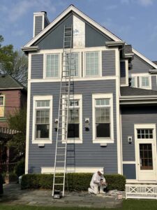 Man next to ladder on side of house