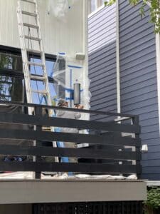Man putting up plastic on side of house