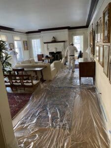 Man covering living room in plastic