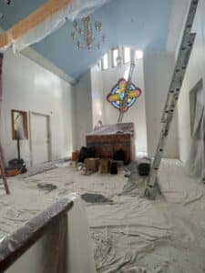 Church room covered on tarps and primed for painting